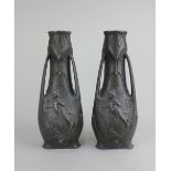 A pair of Art Nouveau bronzed metal vases signed J Garnier, decorated with fairies in raised