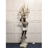 A Venetian style Blackamoor figural standard lamp with standing figure holding a ten light