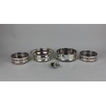 A pair of silver plated bottle coasters with pierced sides, 10.5cm, two single bottle coasters, 12.
