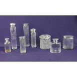 A collection of eight various silver lidded glass dressing table jars some with engraved intials,