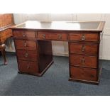 A 19th century mahogany pedestal desk with tooled leather inset top and nine drawers with brass ring