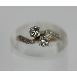 A diamond two stone crossover ring, central stones brilliant cut and claw set, shoulders with