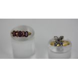 A diamond cluster ring set in white and yellow metal, together with a garnet three stone ring in 9ct