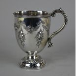 A Victorian silver christening mug embossed with floral swags, foliate cast scroll handle, maker