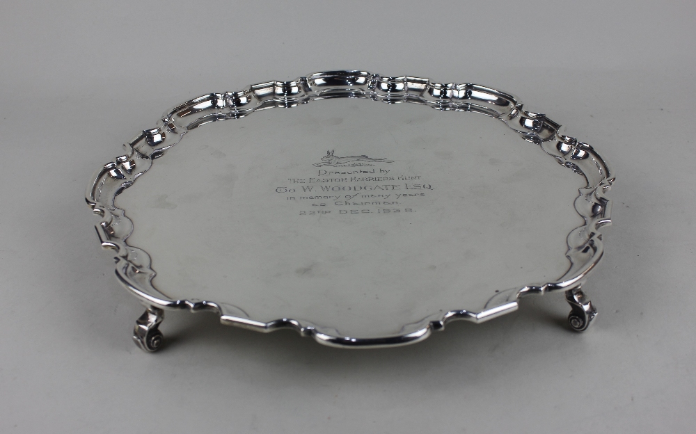 A George VI silver salver with pie crust border on four scroll feet, presentation inscription, maker