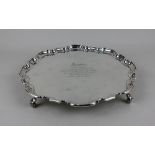 A George VI silver salver with pie crust border on four scroll feet, presentation inscription, maker