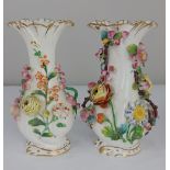 A pair of early 19th century Derby porcelain vases white glazed mounted with flowers in relief (a/f)