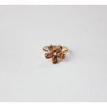 A 9ct gold garnet flower shaped ring with central tiny diamond