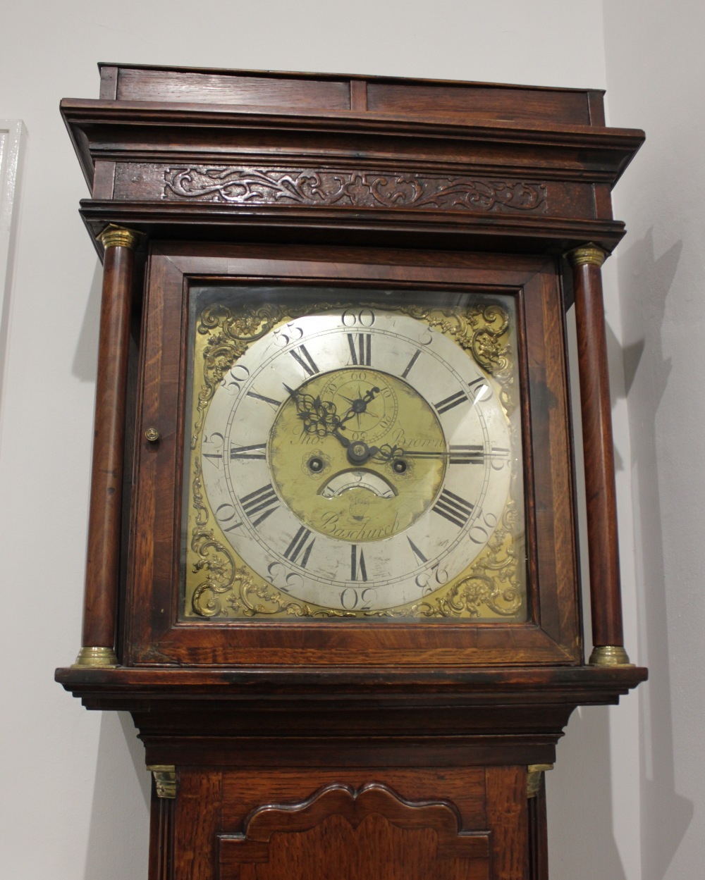 A George III crossbanded oak eight-day longcase clock by Thomas Brown of Baschurch, square hood with