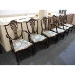 A set of six Sheraton style shield back dining chairs with carved Prince of Wales feathers pierced