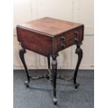 A 19th century mahogany work table with two drop flaps and two drawers on four elaborately carved