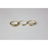 Three small single white stone rings variously mounted in yellow gold