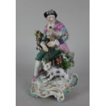 A Derby porcelain figure of a gentleman playing bagpipes with a dog at his feet, with floral