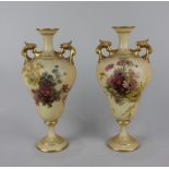 A pair of Royal Worcester blush ivory porcelain two-handled baluster vases decorated with flowers