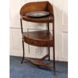 A George III inlaid mahogany bowfronted corner washstand with apertures for basin and pots,