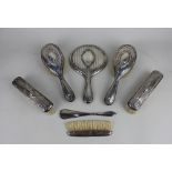 A George V silver five piece dressing table set of hand mirror and four brushes, Birmingham 1928,