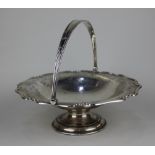 An Edward VII silver basket with serpentine shaped and foliate engraved border on pedestal base,