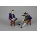 A pair of 19th century porcelain figures of gentlemen in Elizabethan costume seated on stools,