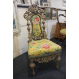 A Baroque style carved oak hall chair with pierced scrollwork and mask surmount and centre panel