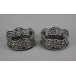 A pair of George III silver bottle coasters with pierced scroll sides and vacant reserves, wavy