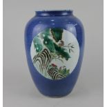 A Chinese powder blue vase of ovoid form decorated with oval panels of birds amongst branches,