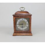 A mahogany cased mantle clock with brass carrying handle, the brass dial with silvered chapter