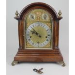 A domed mahogany chiming mantle clock, with Roman numerals to a silvered chapter ring, subsidiary