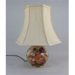 A Moorcroft pottery baluster table lamp decorated with sparrows, apricots and grapes, in orange