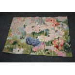 A woven floral rug or wall hanging decorated with large flowers on blue and green ground, with label