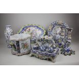 A collection of faience pottery tableware to include a pair of candlesticks with floral and