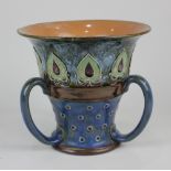 A Royal Doulton stoneware tyg with tube lined foliate and patterned decoration on blue ground 18.5cm