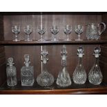 A collection of six various cut glass decanters, a cut glass jug, and a set of six cut glass wine