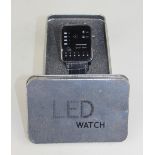 An Origin 'binary watch', in metal tin