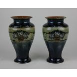 A pair of Royal Doulton blue glazed stoneware vases each with a green band decorated with white