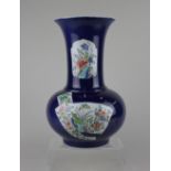 A Chinese powder blue porcelain vase, decorated with panels of flowers and butterflies, the base