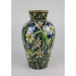 A Doulton Lambeth faience baluster vase by Isabella Miller decorated with daffodils on blue
