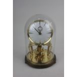 A Kundo brass anniversary clock under a glass dome clock 20cm high including base