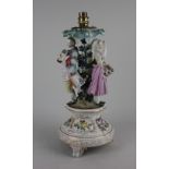 A Dresden porcelain figural table lamp with applied foliate decoration modelled with a lady and