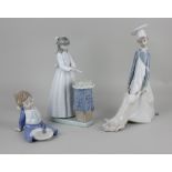 A Lladro porcelain figure of a chef holding a pig 25cm high, together with two Nao porcelain figures