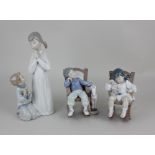 A pair of Lladro porcelain figures of children asleep in rocking chairs 12cm high, together with a