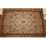 An Aubusson style needlework rug, with floral and foliate decoration on cream ground, 272cm by 173cm