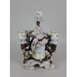 A Sitzendorf porcelain three light candelabra decorated with a lady amongst blossoming branches on