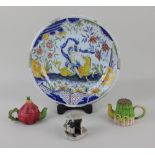 A faience plate with figural decoration 25cm diameter, together with three ceramic items to