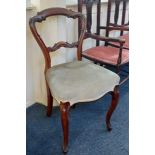 A Victorian scroll carved balloon back dining chair with overstuffed seat on cabriole legs