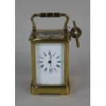 A 19th century French brass repeater carriage clock striking on a gong, the white enamel dial with