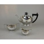An Edward VII silver three-piece bachelor tea set demi-fluted oval shape with teapot, cream jug