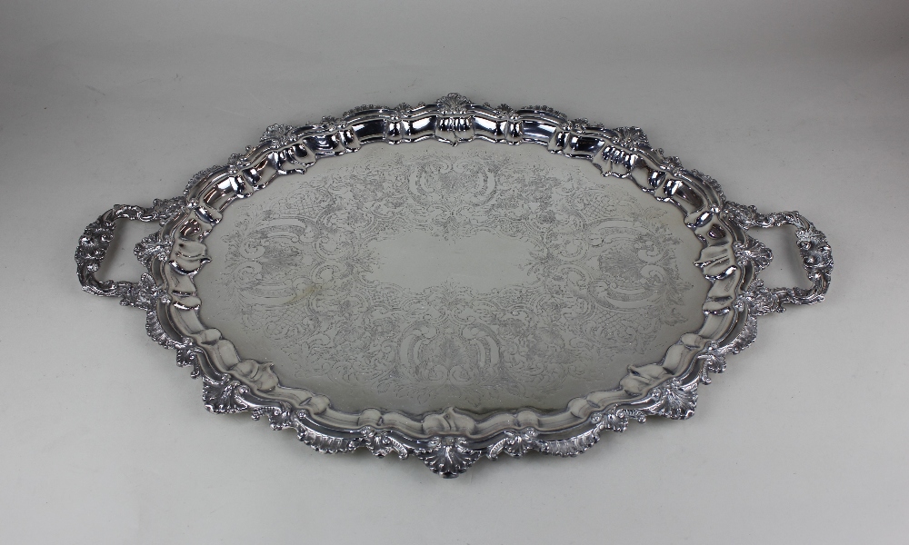 A silver plated two-handled oval serving tray with shell and pie crust border and engraved