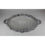 A silver plated two-handled oval serving tray with shell and pie crust border and engraved