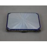 A George VI silver cigarette case with silver guilloche and blue enamelled lid and gilt interior