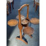 An Edwardian oak 'The Monoplane' cake stand with five platforms, maker's labels verso 78cm high